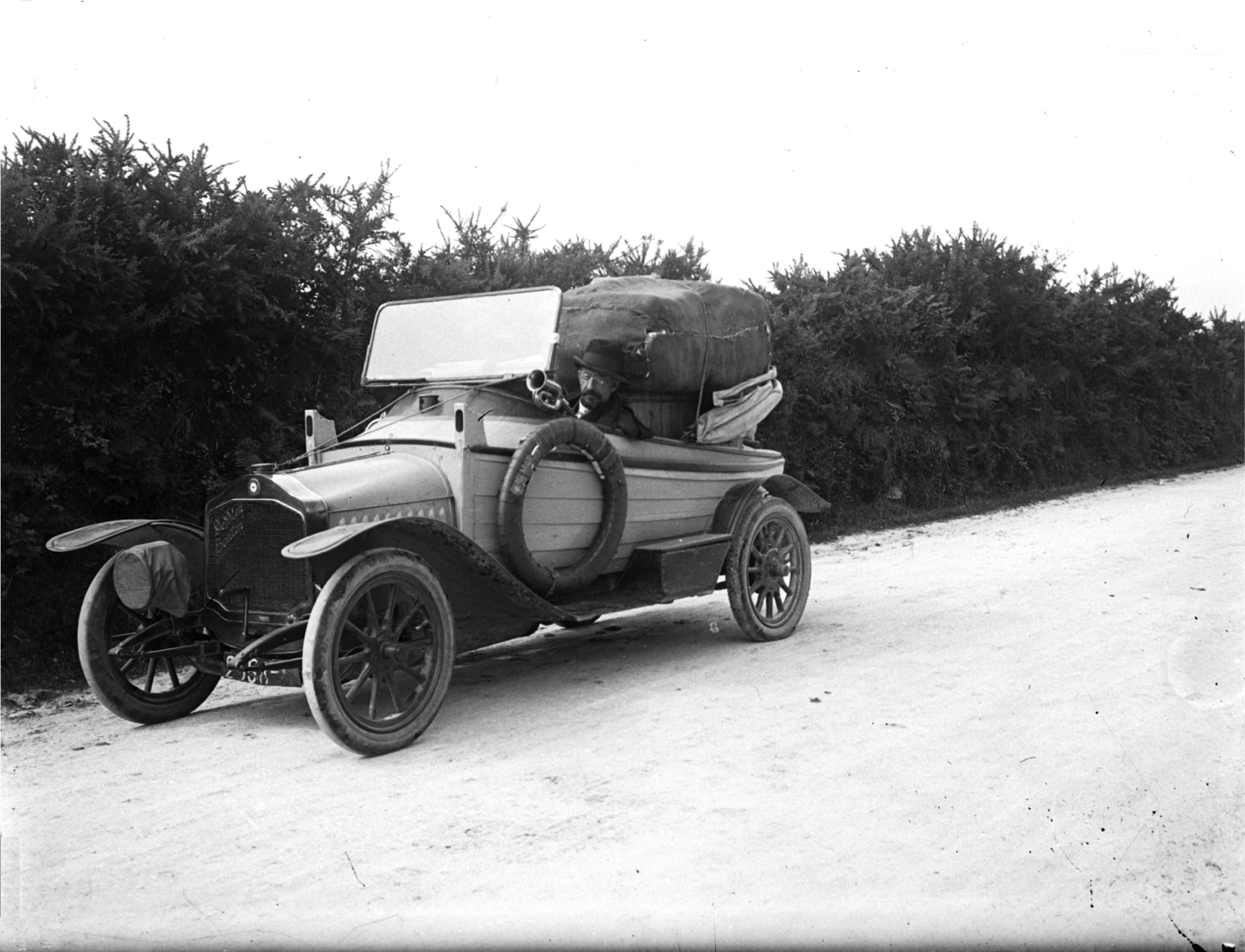 Jacques de Thézac dans son auto-canot bordée à clins ; le véhicule est chargé de ballots de feuilles d'eucalyptus (photo de P. Quéméré).